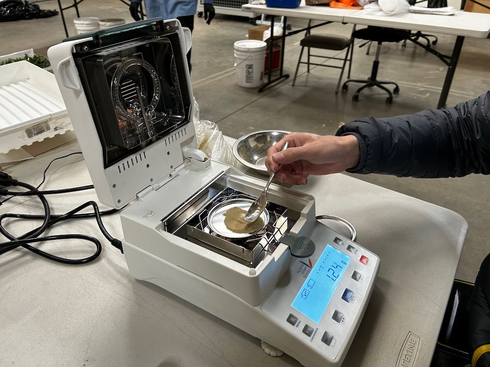 A person using a moisture analyzer to measure moisture content